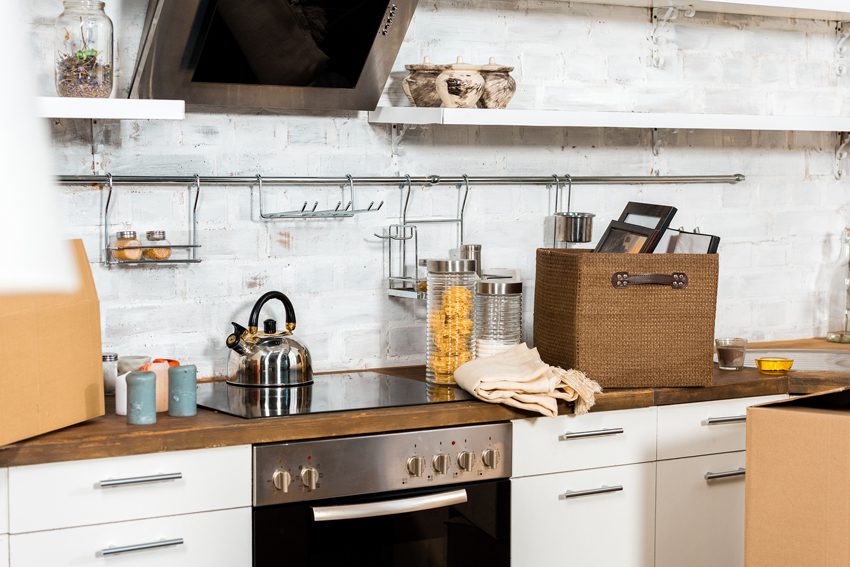 interior of modern kitchen with cardboard boxes during relocation at new home