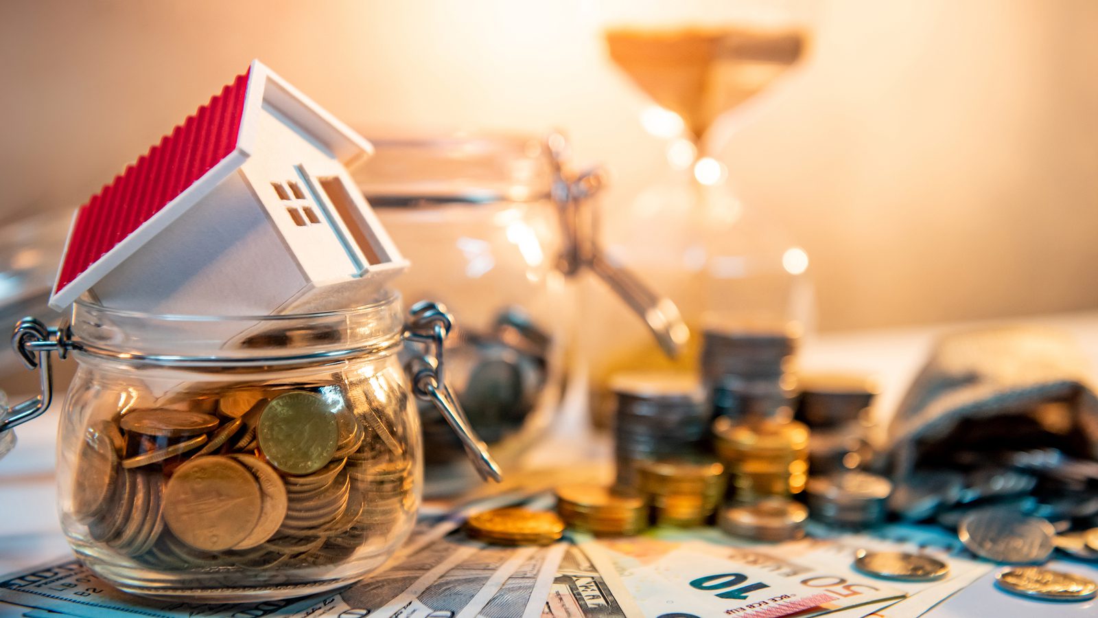 stacks of coins and model house representing a sold property